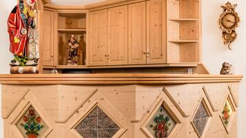 Un armadio in legno con pannelli decorativi e un orologio appeso al muro.