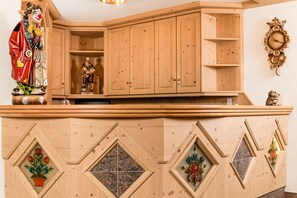 Ein Holzkabinet mit verzierten Paneelen und einer Uhr an der Wand.
