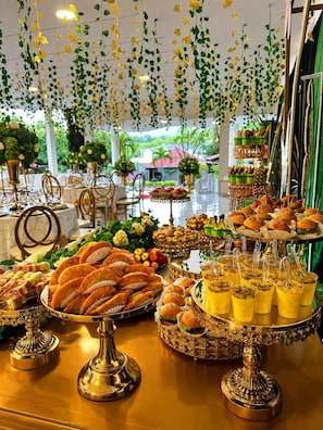 A buffet table with various food items and decorative elements.