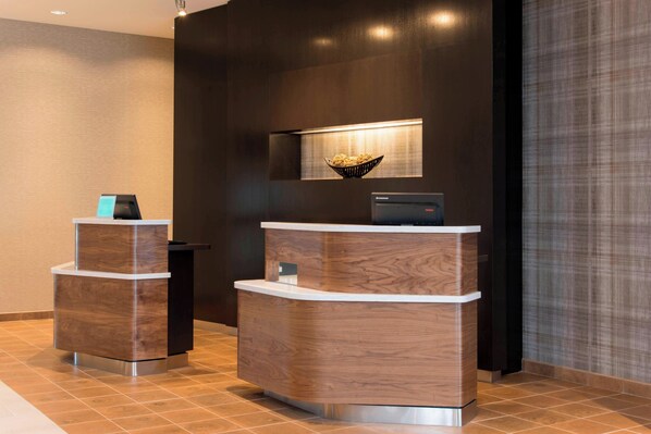 A reception desk with a modern design, a small bowl of snacks, and a digital display.