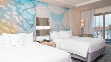 A hotel room with two beds, a large window, a wall mural, a nightstand, and a lamp.
