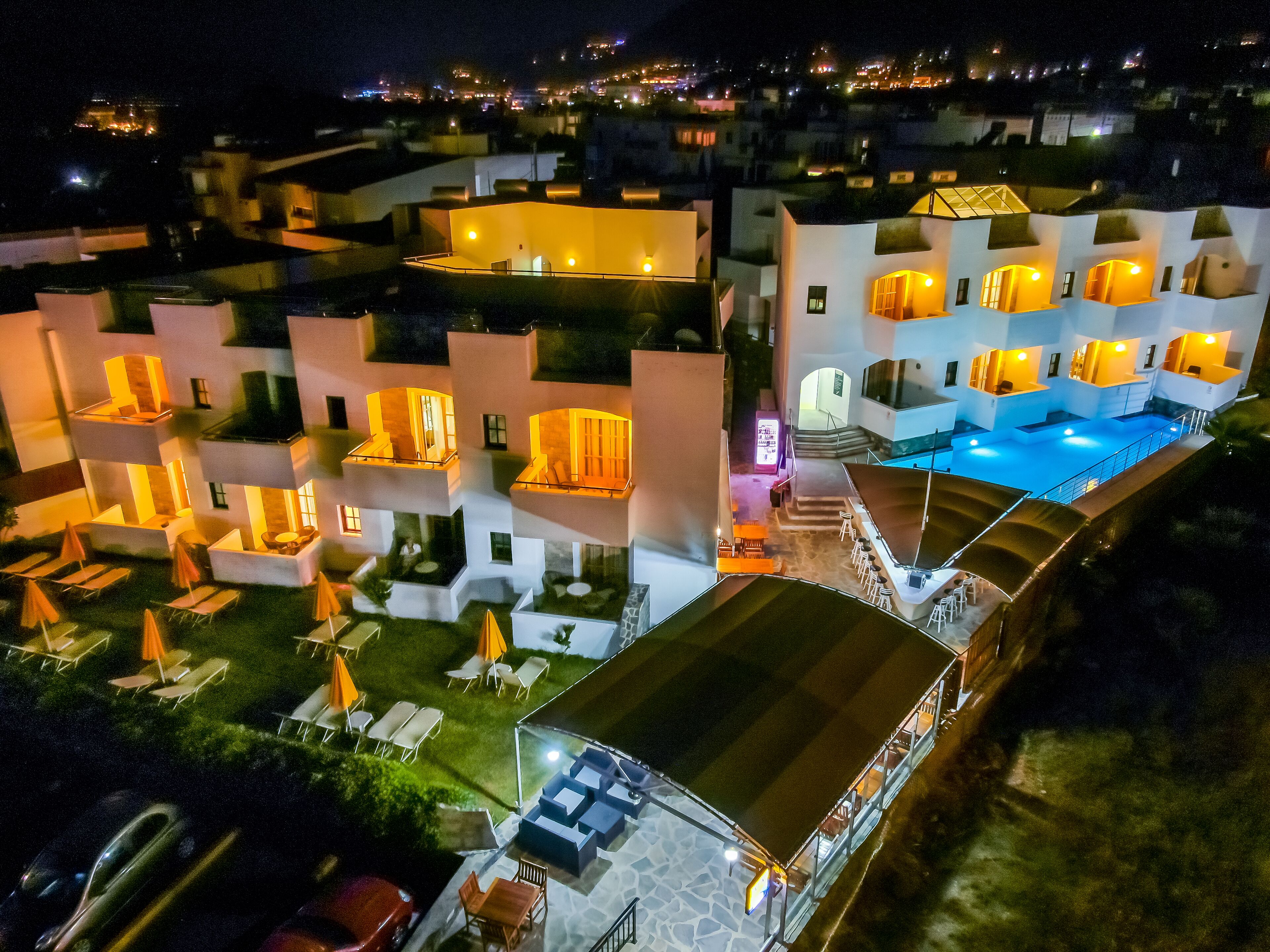 A multi-story hotel with outdoor seating and a swimming pool.