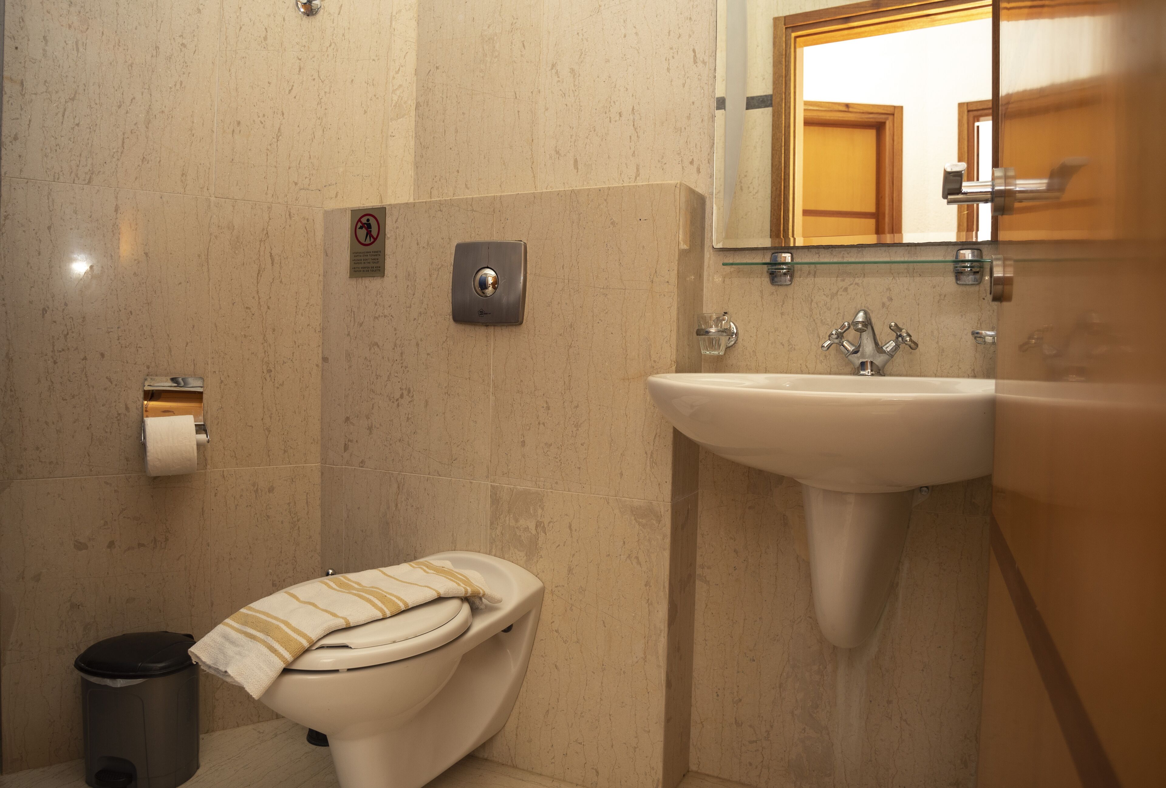 Une salle de bain avec des toilettes, un lavabo et un miroir.