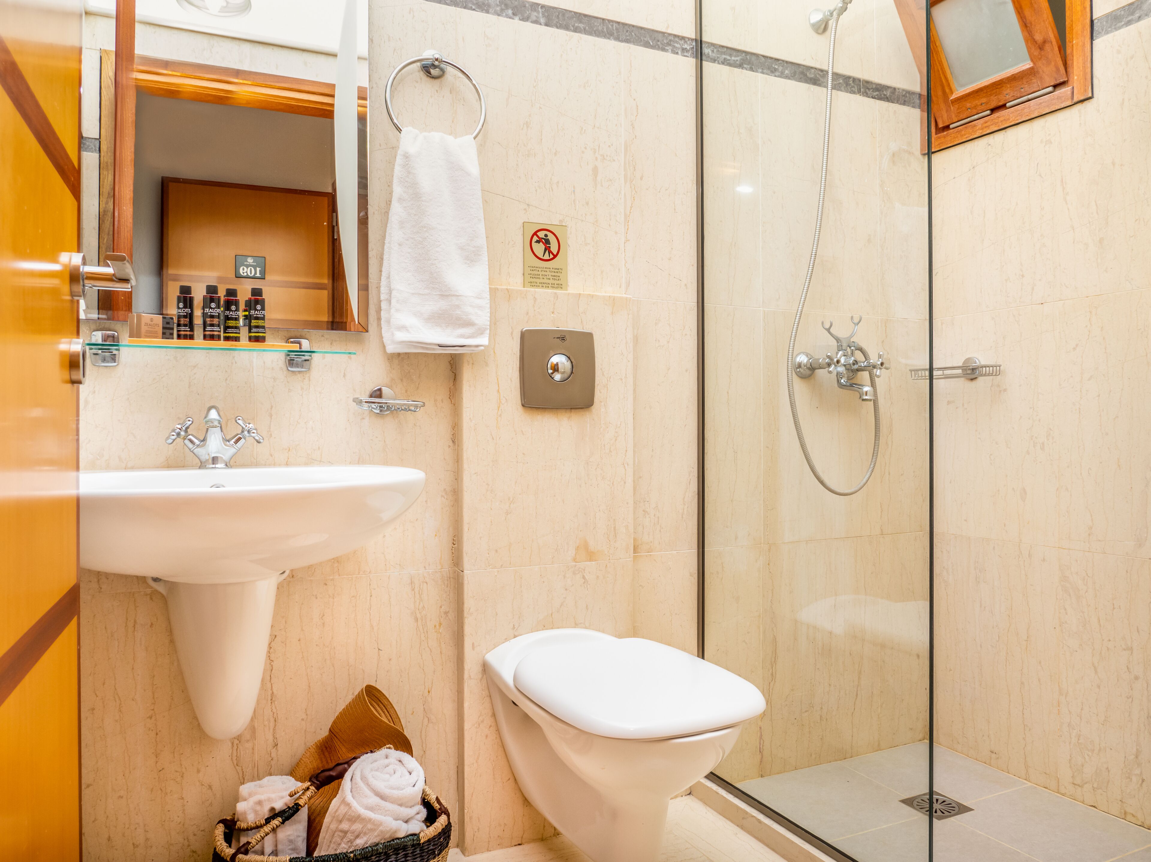 A bathroom with a sink, toilet, and glass-enclosed shower.