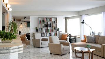 Suite, vista al mar | Área de sala de estar | Televisión de pantalla plana