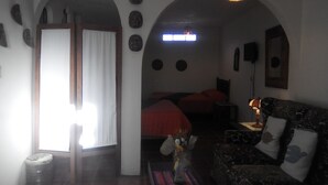Een kamer met een bed, een bank, een lamp en een muur met ronde decoraties.