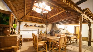 A rustic kitchen with wooden furniture, a large wooden table, and a chimney. - El Huarango Hotel (Ica)