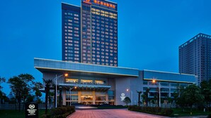 A Sheraton hotel with a modern design, featuring a prominent entrance and a tall building with illuminated signage. - Sheraton Chuzhou Hotel (Chuzhou)