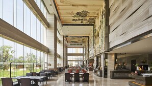 A spacious hotel lobby with high ceilings, large windows, and a central seating area. - Sheraton Chuzhou Hotel (Chuzhou)