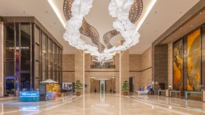 A spacious lobby with a modern chandelier, glass walls, and a reception desk. - Sheraton Chuzhou Hotel (Chuzhou)