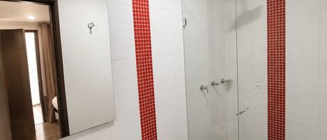 A bathroom with a white sink, toilet, and a glass shower enclosure.