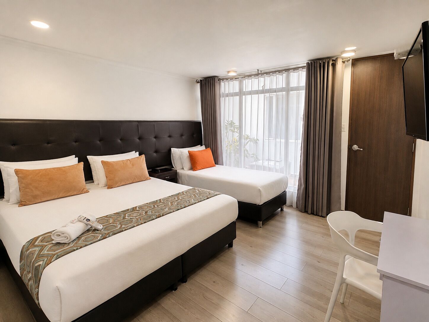 Une chambre d’hôtel avec un grand lit, un bureau et une chaise.