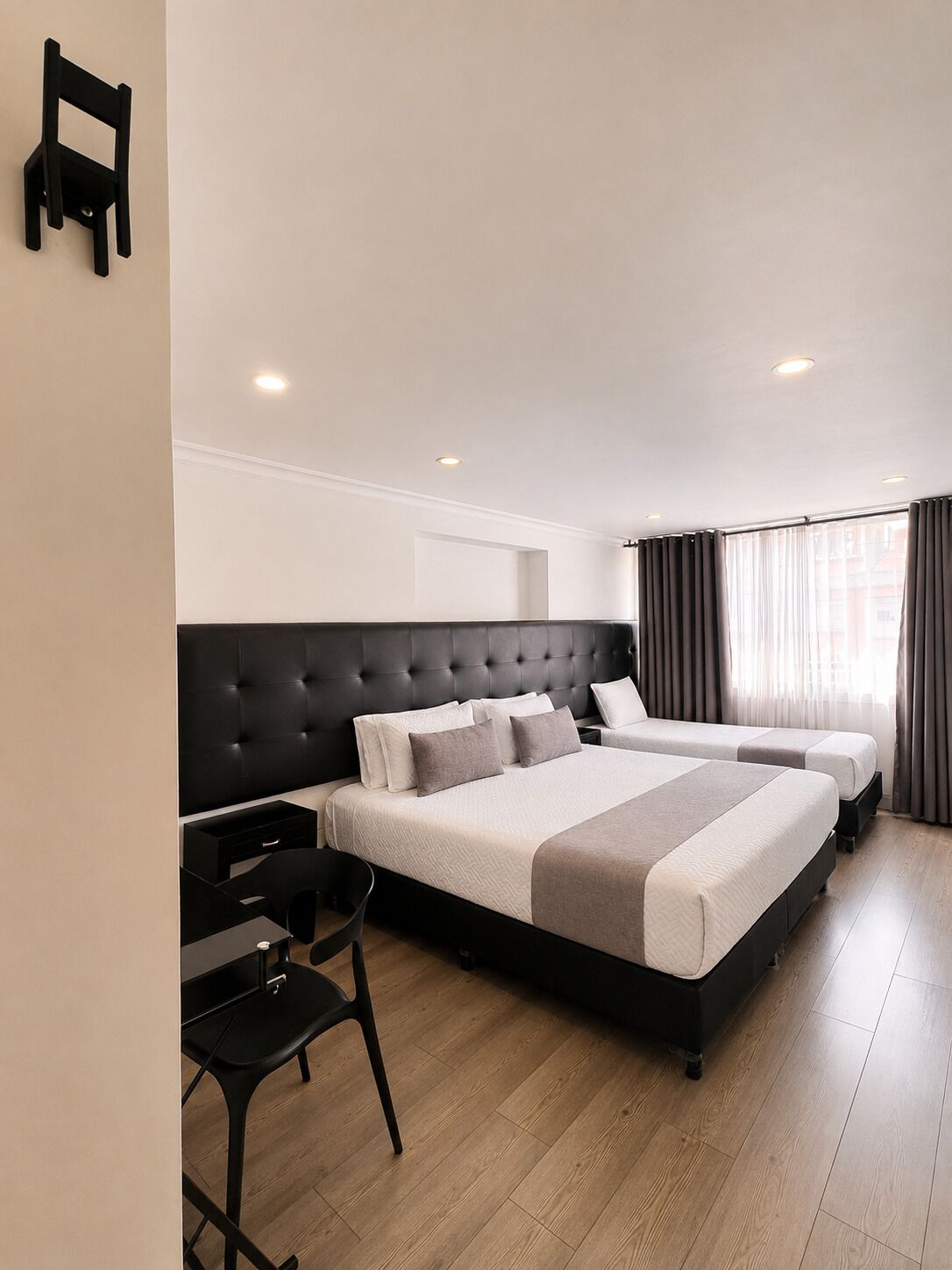 Habitación de hotel moderna con una cama grande, un escritorio y una silla.