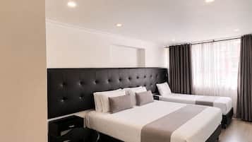 A modern hotel room with a large bed, a desk, and a chair.