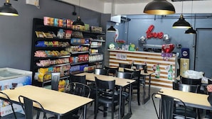 A cafe with tables and chairs, a counter with snacks, and a 'love' sign on the wall. - F2M Tower (Legazpi)