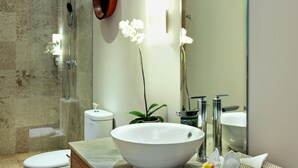 A modern bathroom with a large white vessel sink, a toilet, a shower, and a mirror. - Room & Vespa 4 (Seminyak)