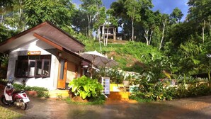 A small building with a sign reading "Café & Restaurant" in front of lush greenery and a hill in the background. - Chang Pai (Pai)