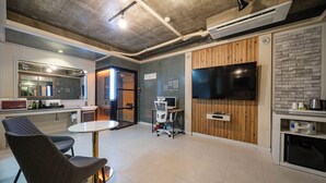 A modern kitchen with a large TV, wooden accents, and a dining area with a round table and chairs.