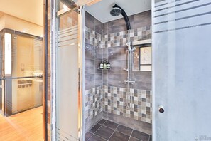 A modern shower area with a glass door, tiled walls, and a showerhead. - Time Hotel (Yangsan)