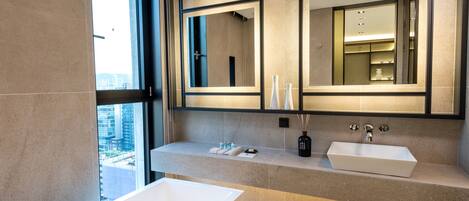 Un baño moderno con una bañera grande, dos lavamanos y un espejo amplio.