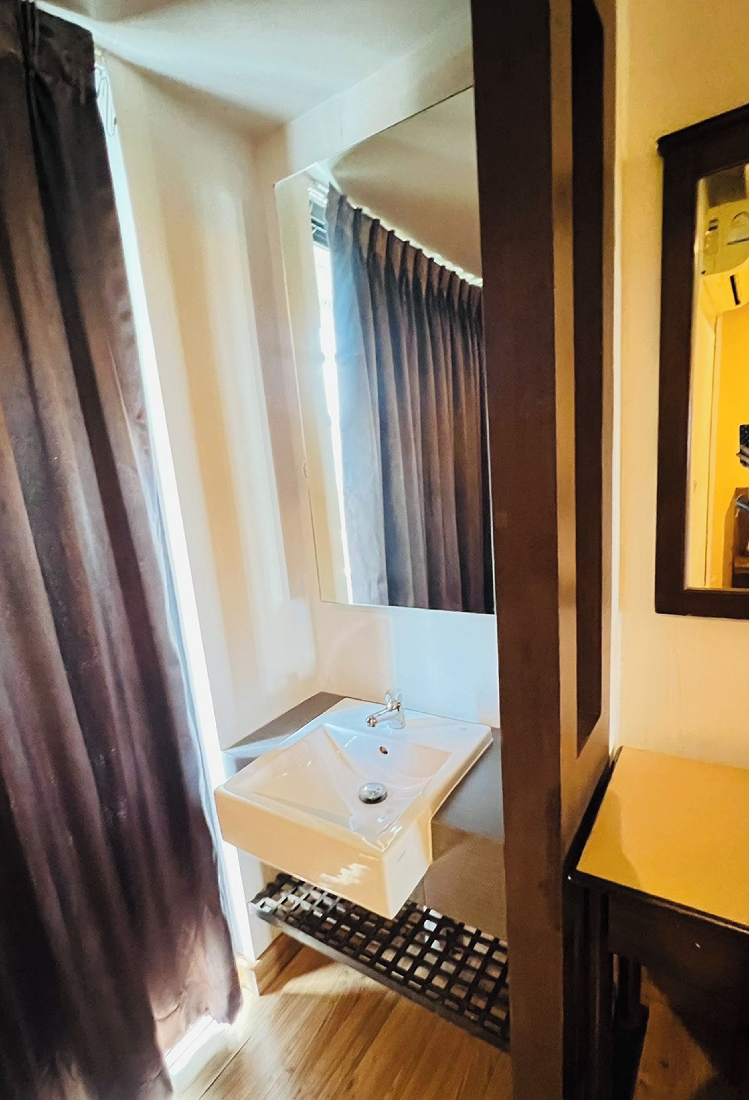 A bathroom with a white sink, a mirror, and a shower curtain.