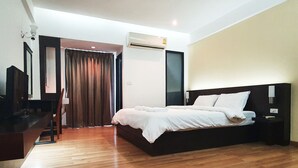 Una habitación de hotel moderna con una cama grande, un escritorio y una televisión.