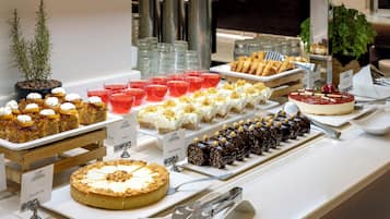 Een buffet met diverse desserts en drankjes.