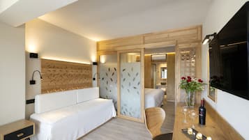 Una habitación de hotel moderna con una cama, un escritorio, una silla, una tocador y un espejo.