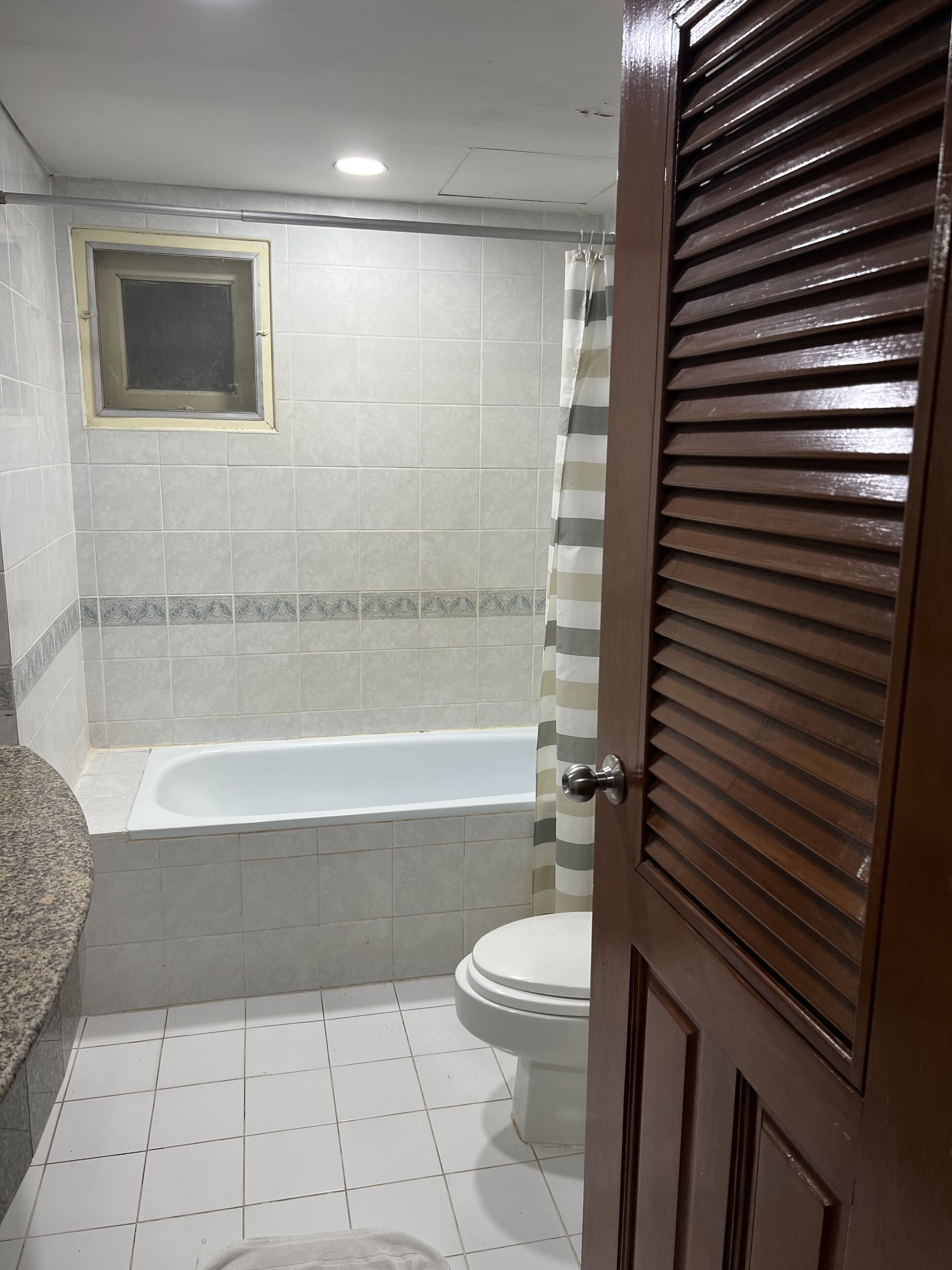Une salle de bain avec une baignoire, des toilettes et un rideau de douche.