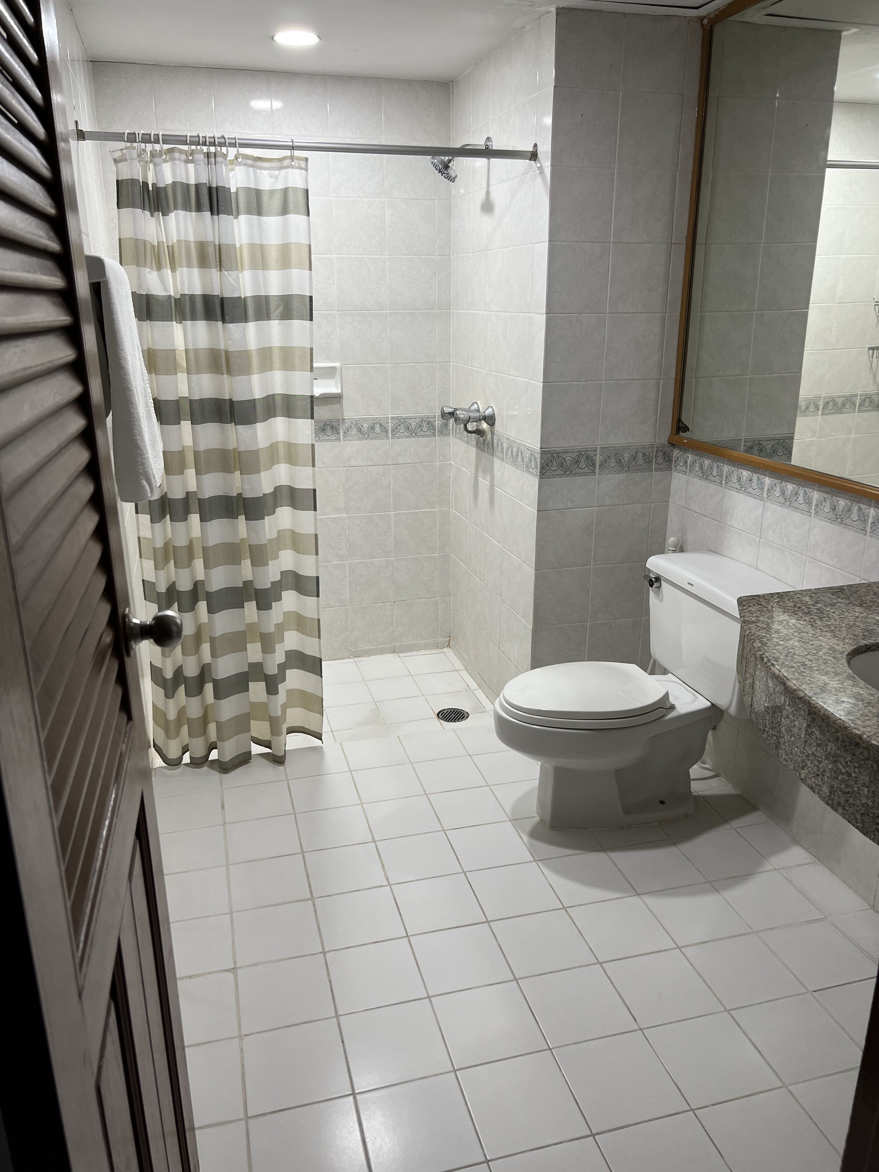 Un baño con ducha, inodoro y lavamanos.