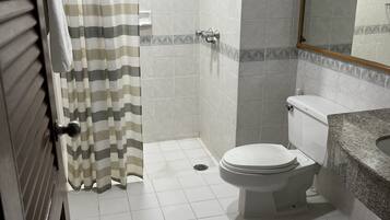 Un baño con ducha, inodoro y lavamanos.