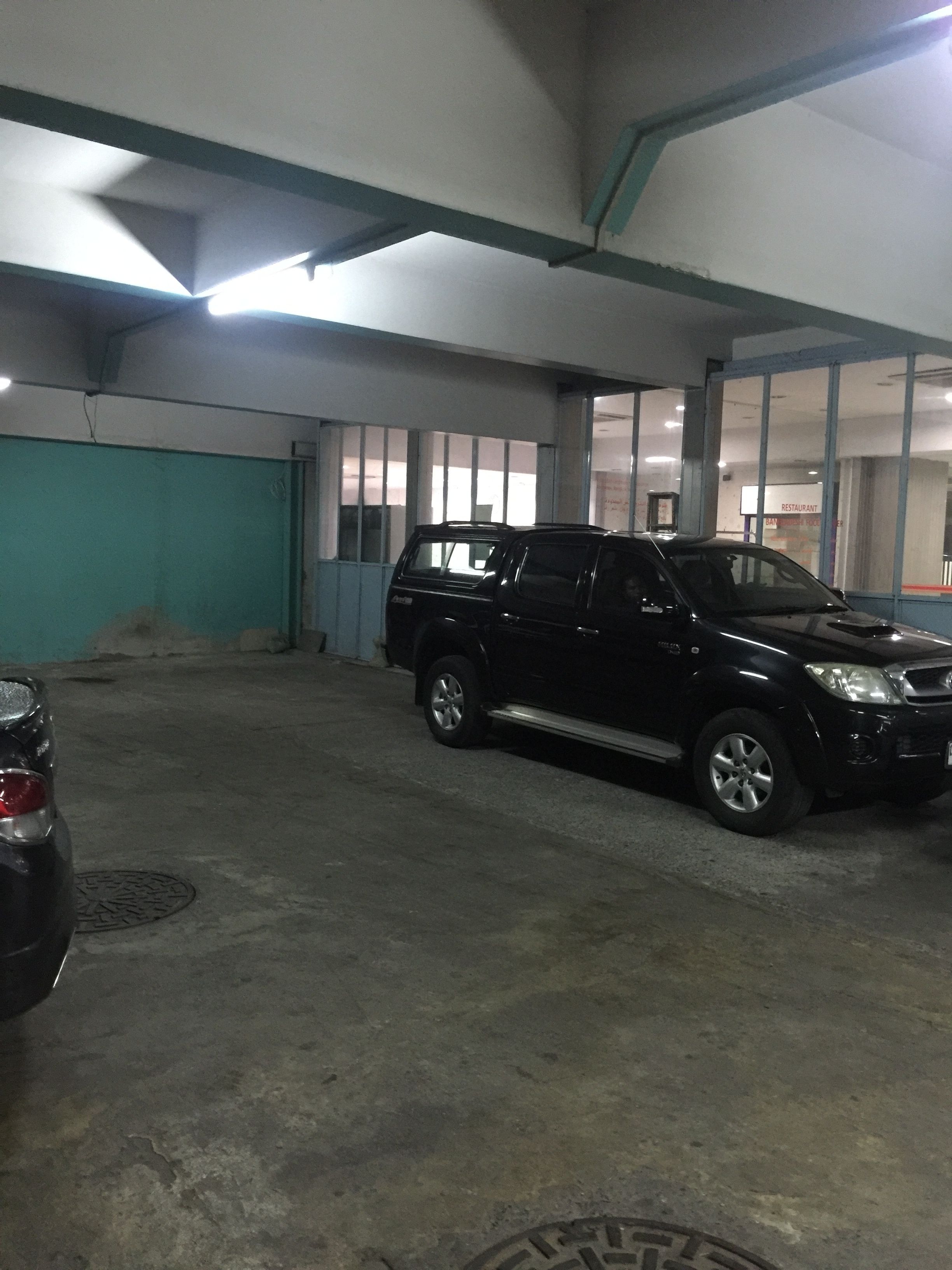 A parking garage with a black SUV parked in a spot.
