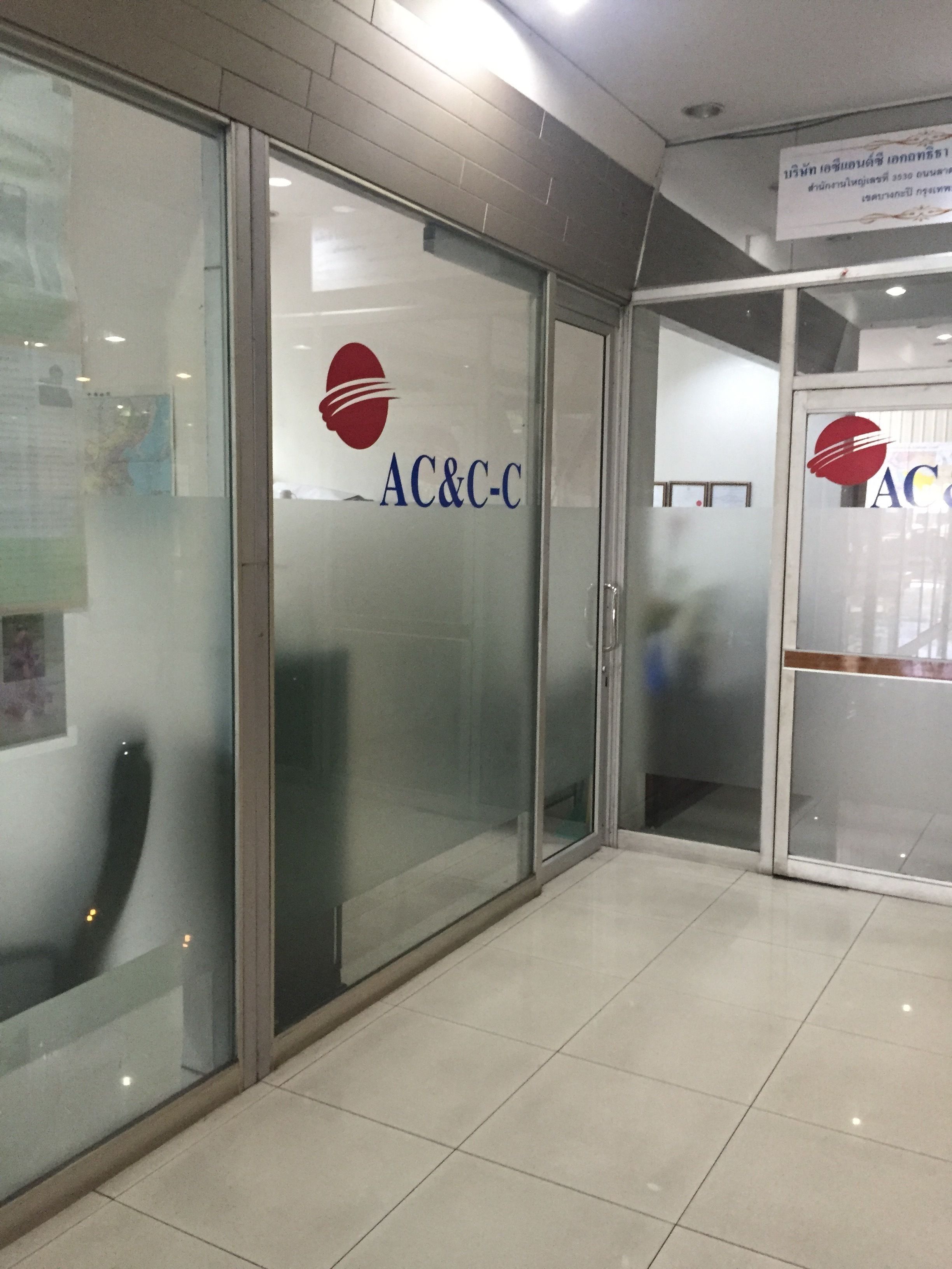A hallway with glass doors marked "AC&C-C" and a tiled floor.