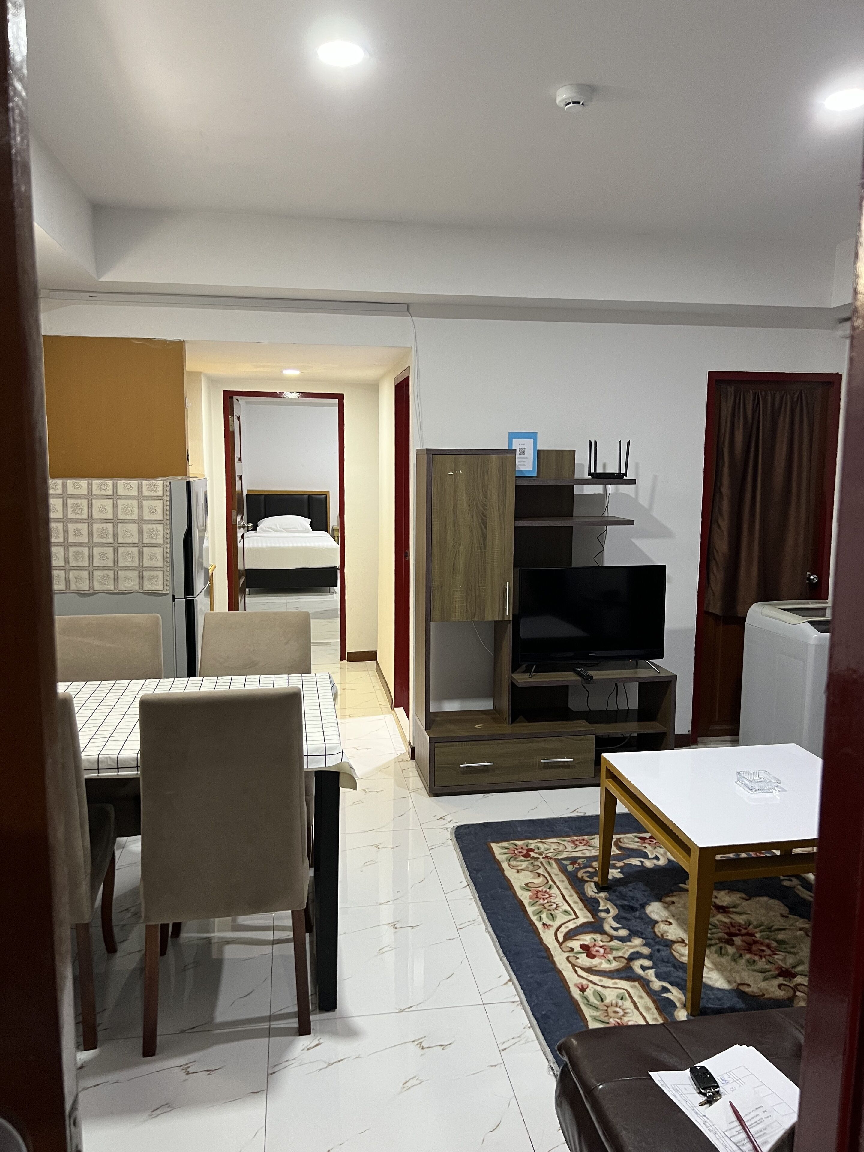 A hotel room with a bed, a desk, a television, and a dining area with chairs and a table.