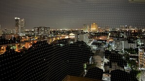 A nighttime cityscape with a grid-like pattern overlay. - Mall Suites Hotel (Bangkok)