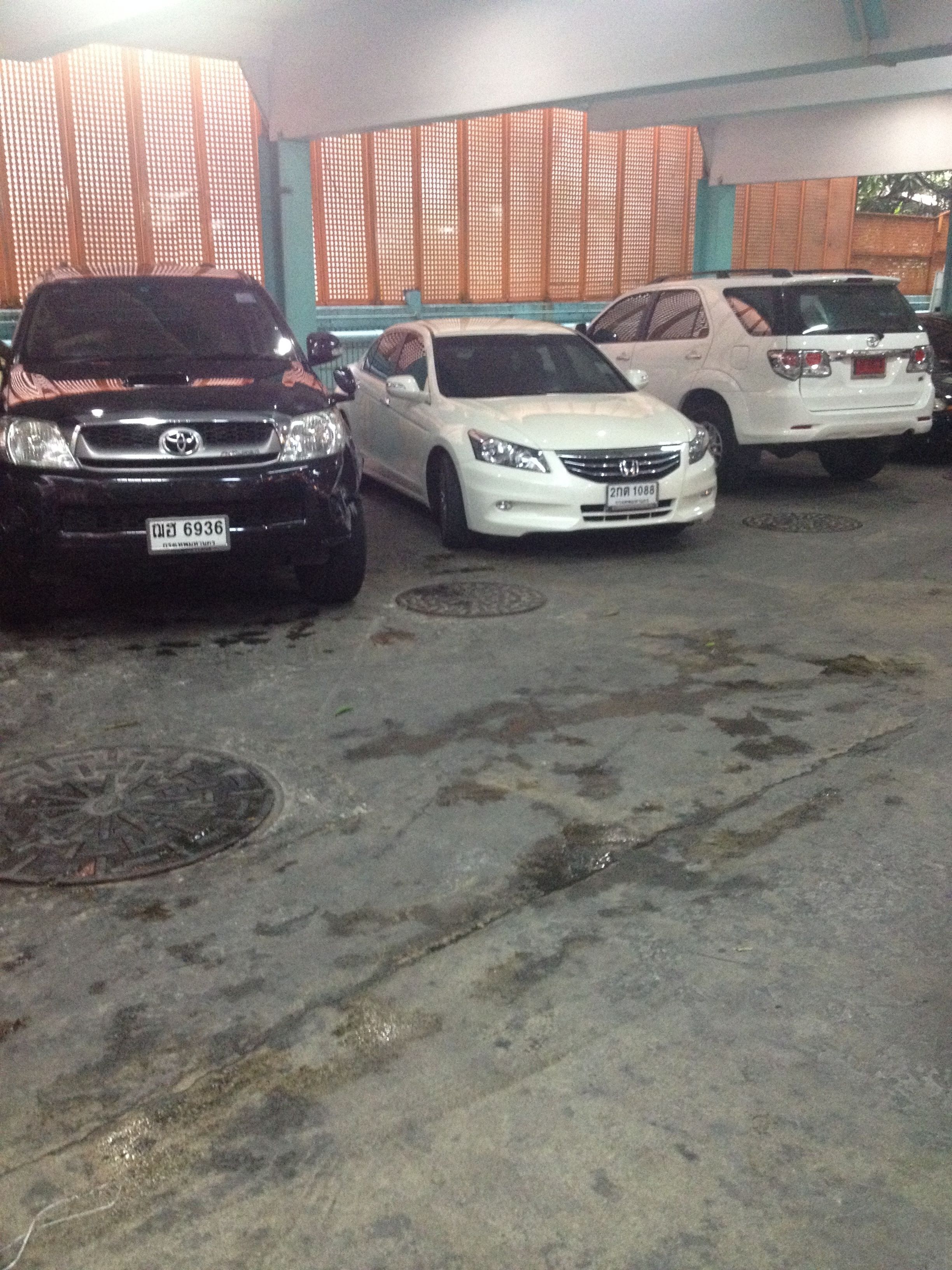 A parking area with several cars parked in a row.