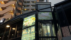 A modern building with multiple floors, featuring balconies and a restaurant named PostAntz. - Mall Suites Hotel (Bangkok)