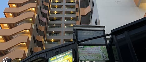 Een modern gebouw met meerdere verdiepingen, voorzien van balkons en een restaurant genaamd PostAntz.