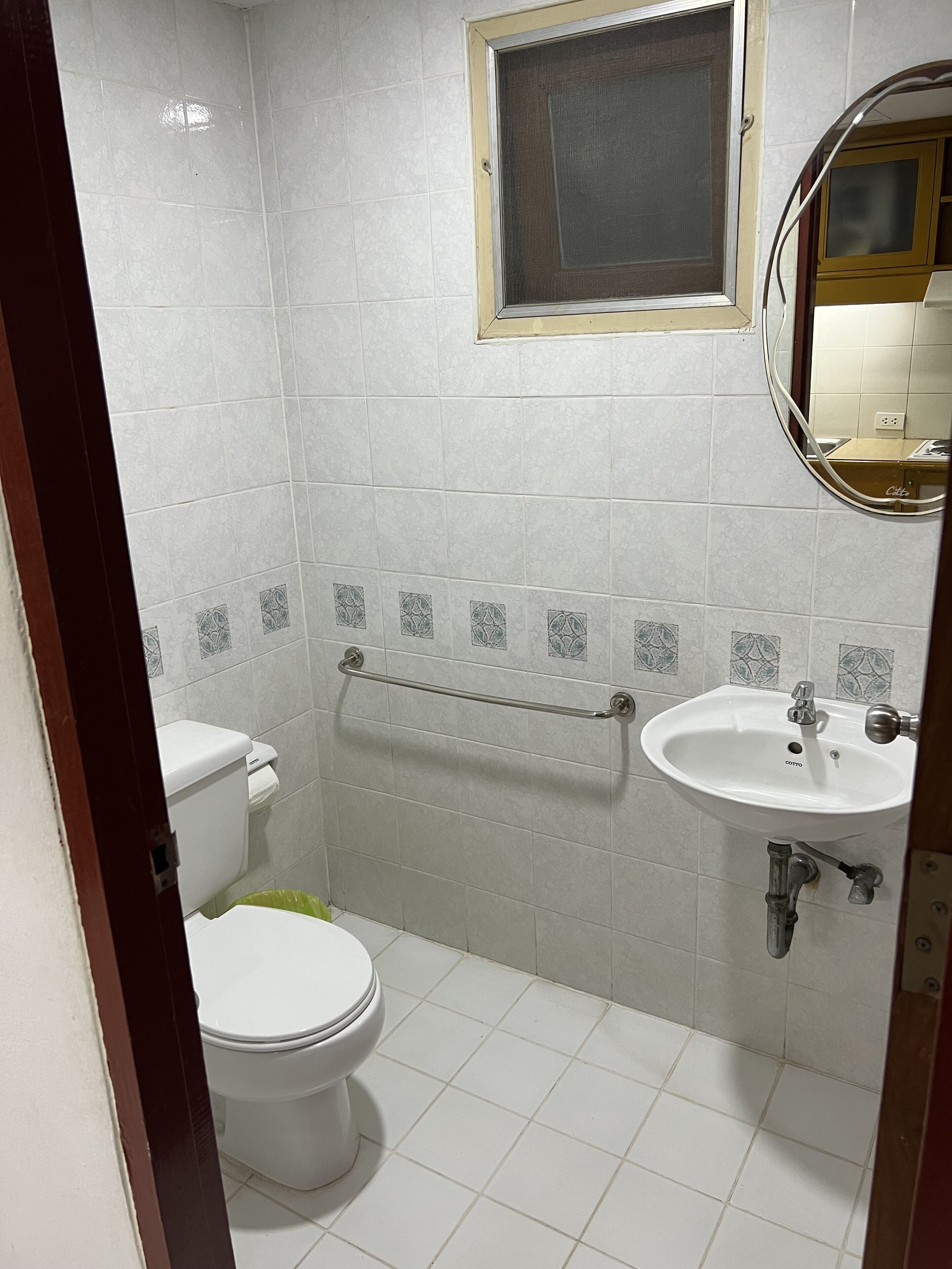 A small, clean bathroom with a toilet, sink, and window.