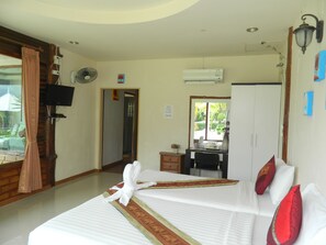 A hotel room with a bed, a desk, an air conditioning unit, a television, and a window with curtains. - Pai Iyara Resort (Pai)