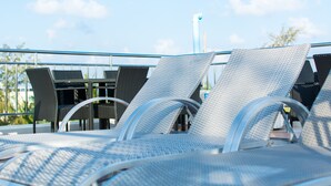 A rooftop terrace with metal-framed lounge chairs and a railing. - BEACH PALACE HOTEL (Hulhumalé)