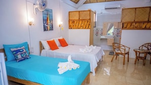 A hotel room with two beds, a sitting area with chairs, a small table, and a bathroom visible through a door. - La Villa Allamanda (Rodrigues Island)