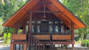 Une structure en bois dotée d’un balcon et d’un escalier menant à un niveau supérieur.
