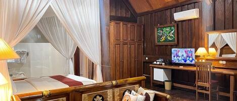 Una habitación con piso de madera, una cama, un escritorio y una silla.