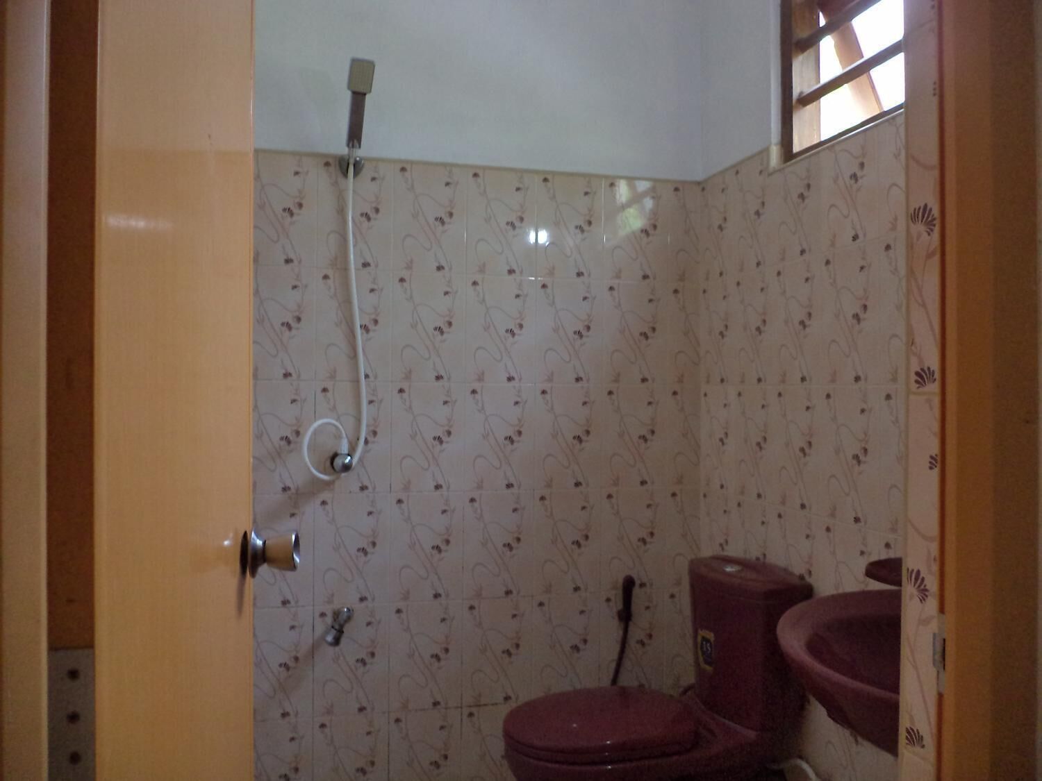 Um banheiro com chuveiro, vaso sanitário e pia.