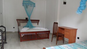 Ein Schlafzimmer mit einem Holzbett, einem Schreibtisch und einem Stuhl.