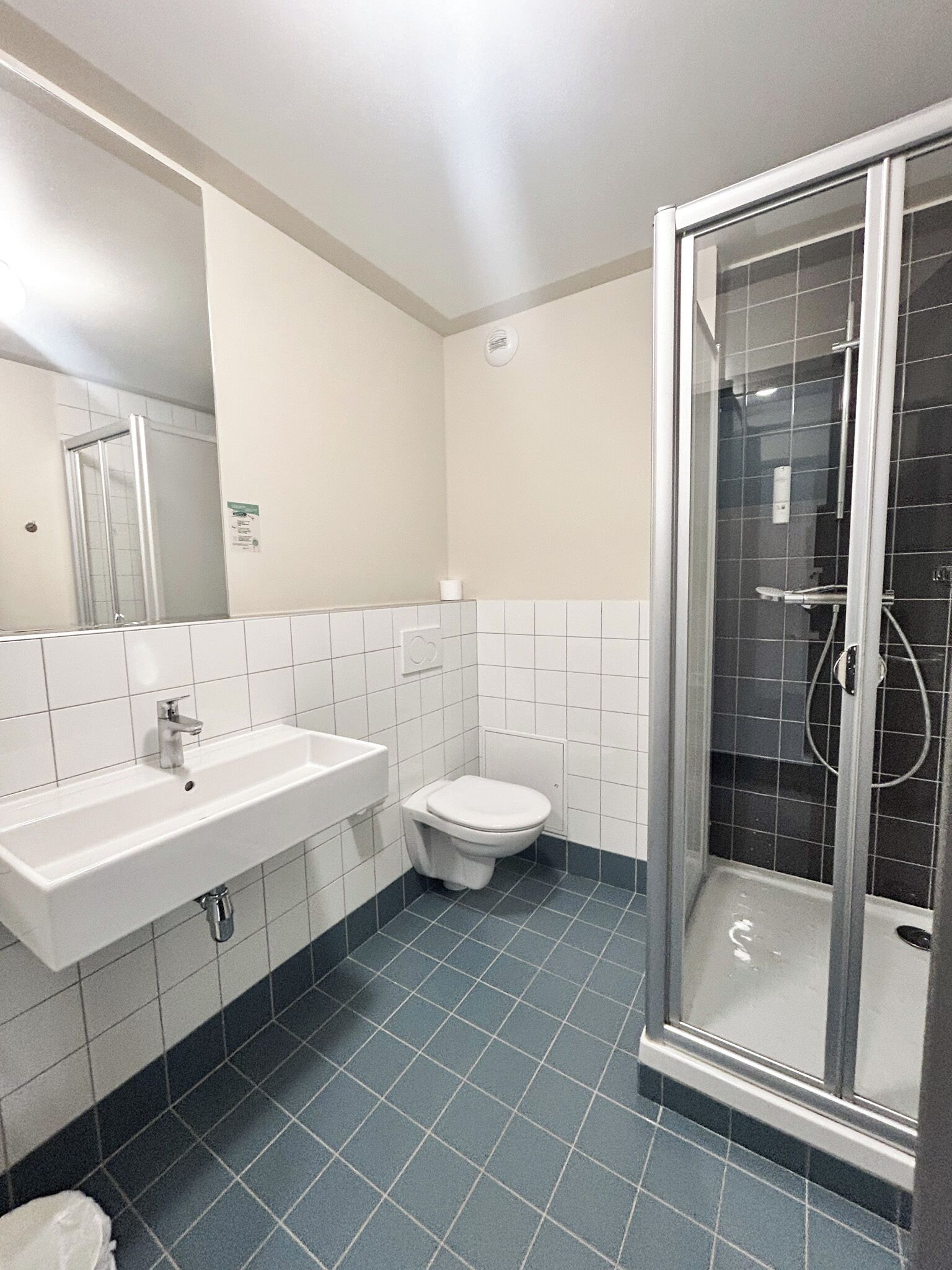 A bathroom with a sink, toilet, and glass-enclosed shower.
