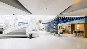 Un intérieur moderne avec un escalier en colimaçon, un coin salon et un café.