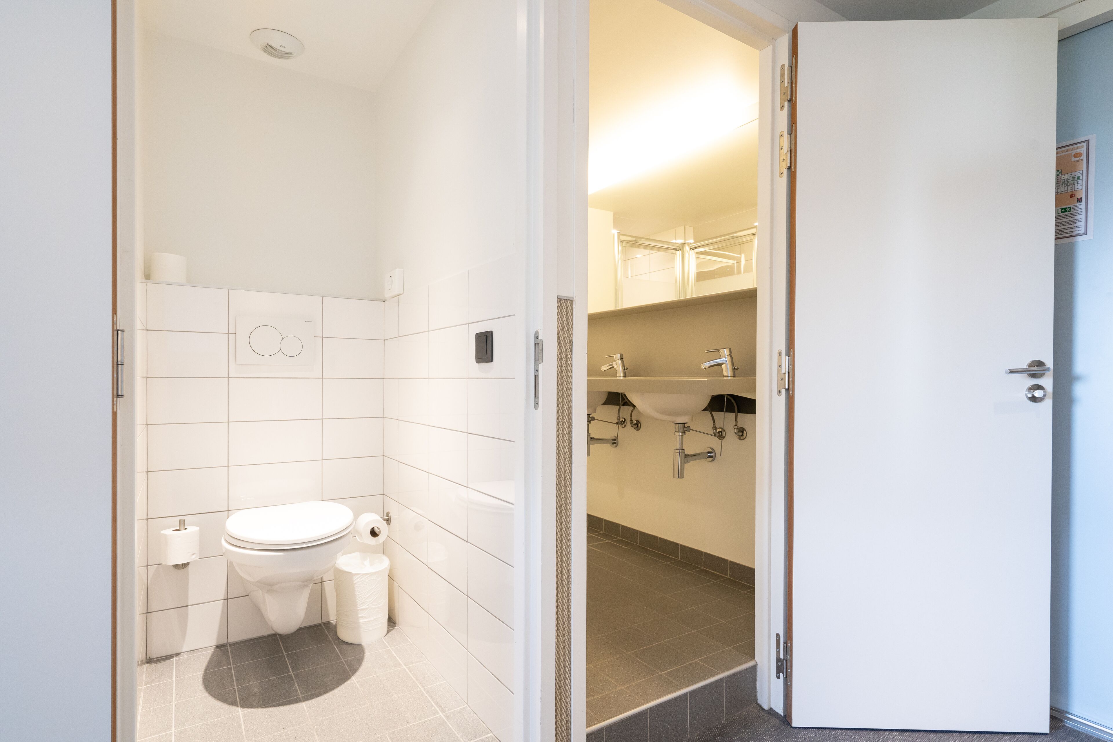 A bathroom with a toilet, bidet, and sink.