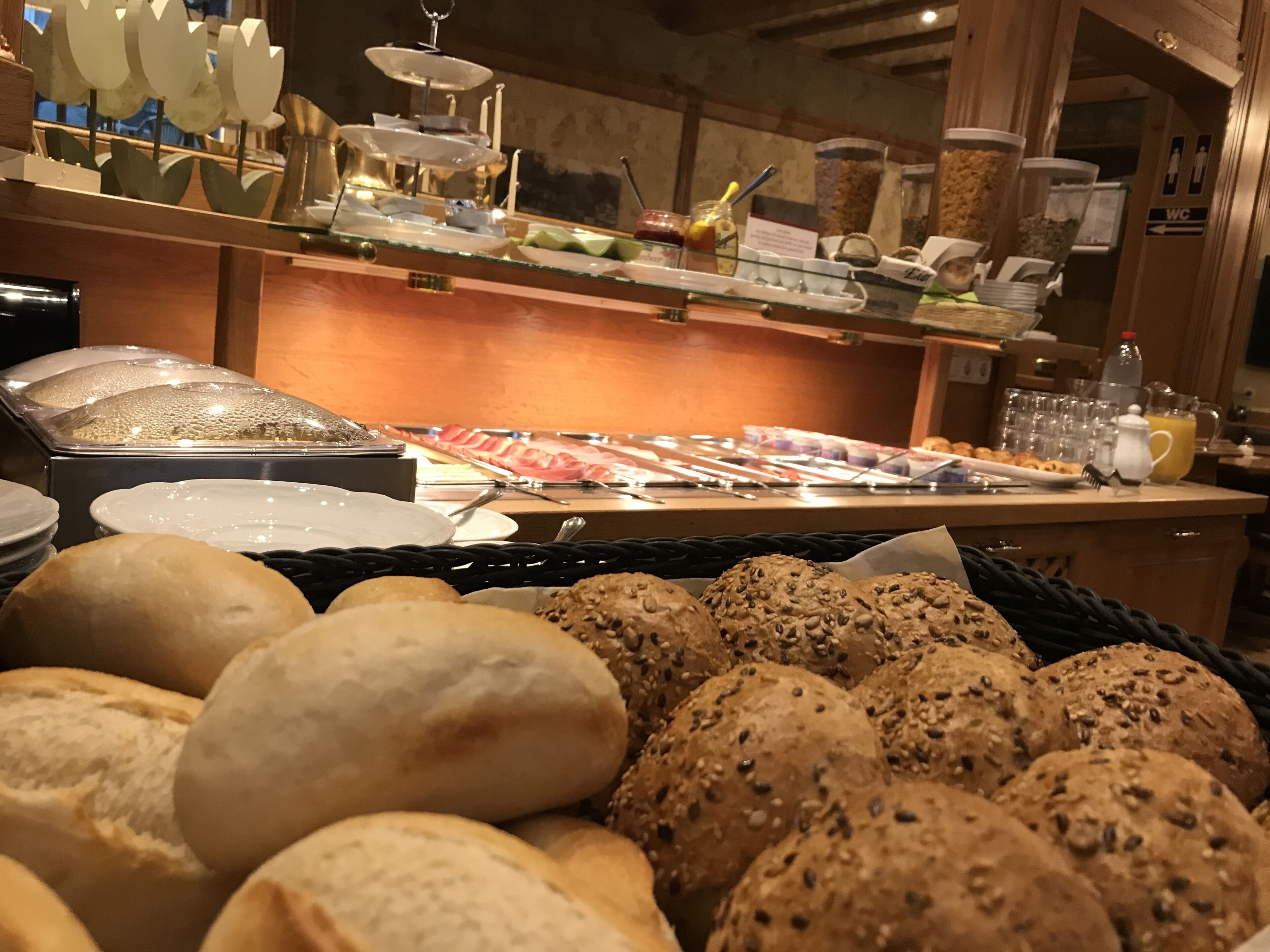 Un buffet proposant une variété de plats, notamment du pain, des pâtisseries et un assortiment de viandes.